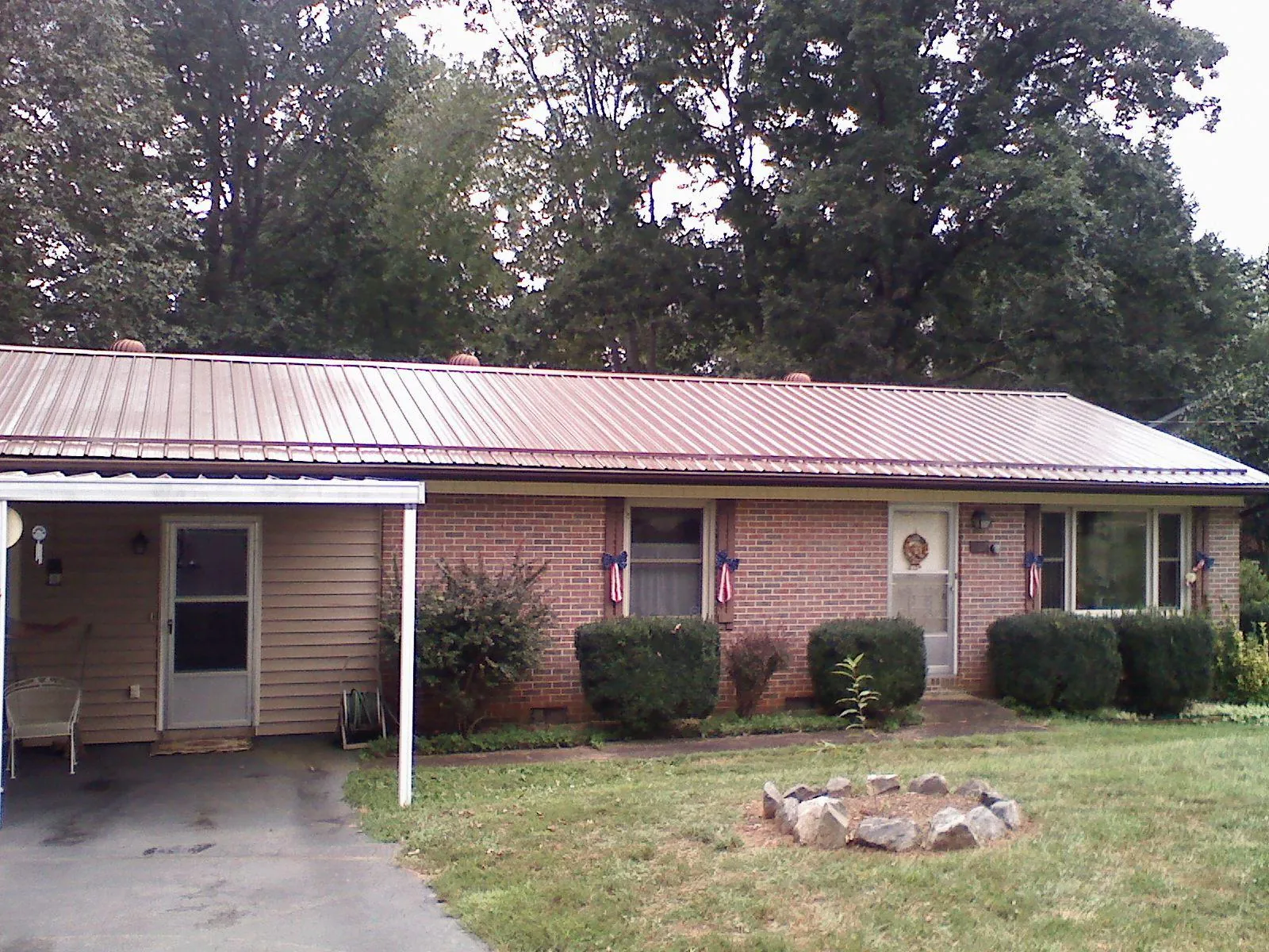 Bronze metal roof and carport on a brick ranch home — Roof Repair work by our crew in Avenel